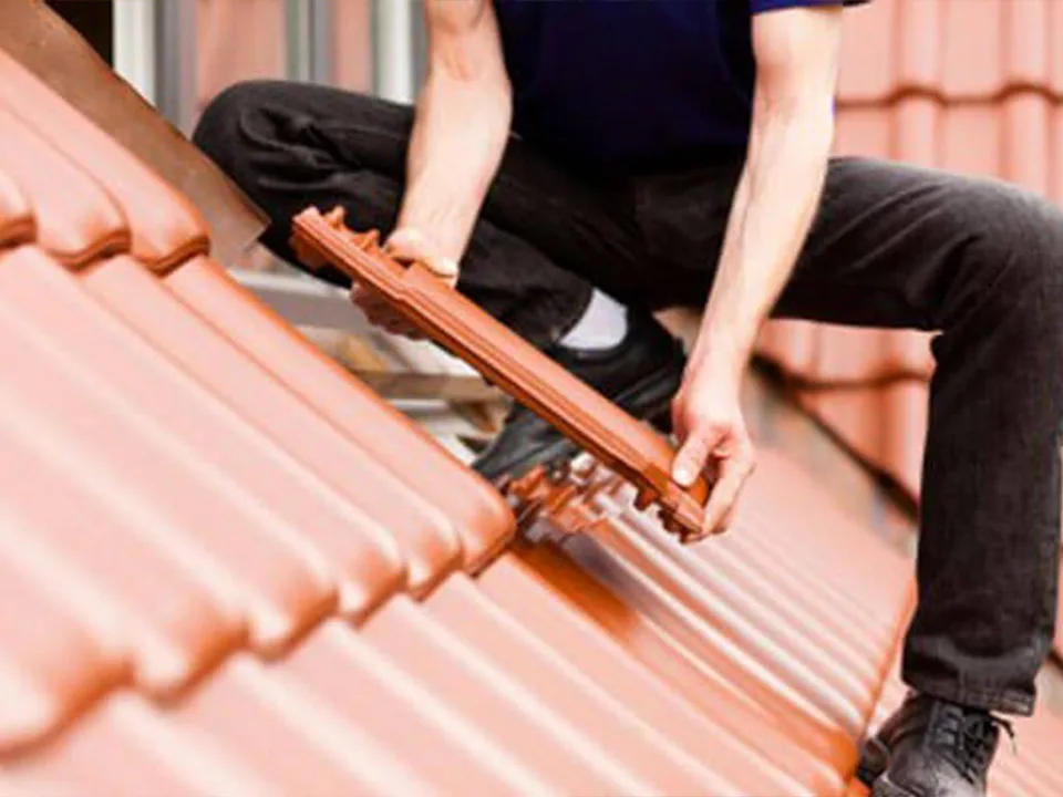 Dachdecker verlegt Dachziegel – fachgerechte Neueindeckung eines Steildachs.