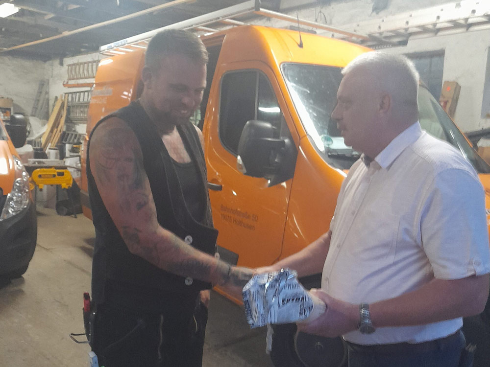 Dachdeckermeister Rainer Thormählen überreicht Mitarbeiter eine Auszeichnung – Anerkennung für hervorragende Handwerksleistung.