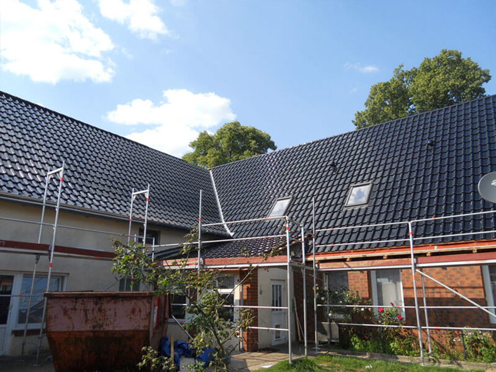 Dachneueindeckung und Sanierung vom Fachbetrieb Frisch gedecktes Ziegeldach mit Baugerüst – Neueindeckung vom Dachdeckermeister.