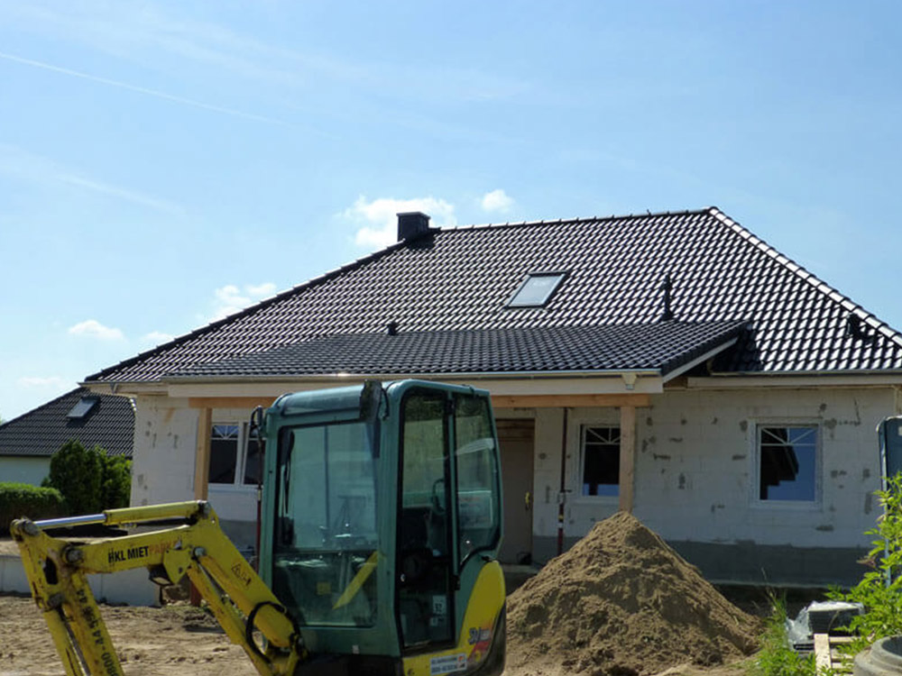 Neubau mit modernem Ziegeldach und Baustellengerät – Dacharbeiten im Meisterbetrieb.